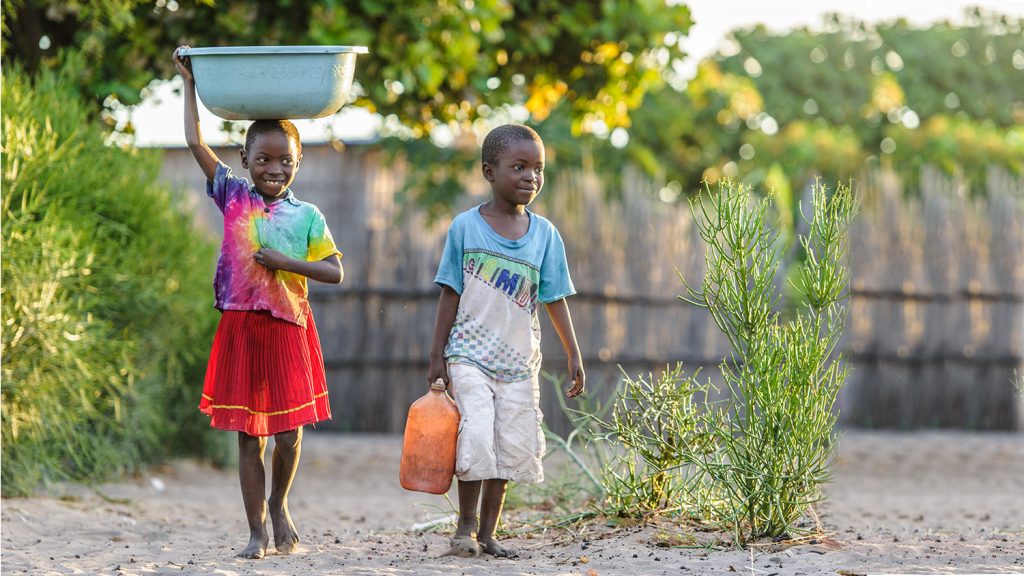 Namukolo og broren hennes bærer vann gjennom landsbyen.