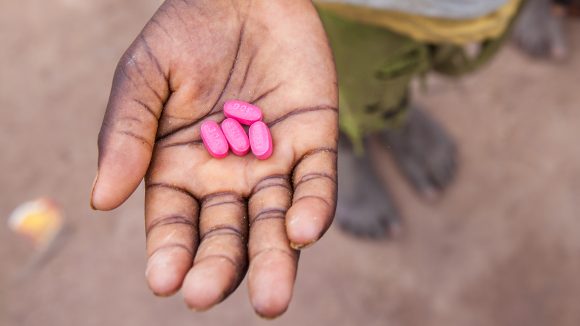 Et barn i Senegal holder Zithromaxtabletter i hånden.