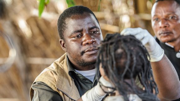 A close up of Mr Ndalela examining a young girls eyes.