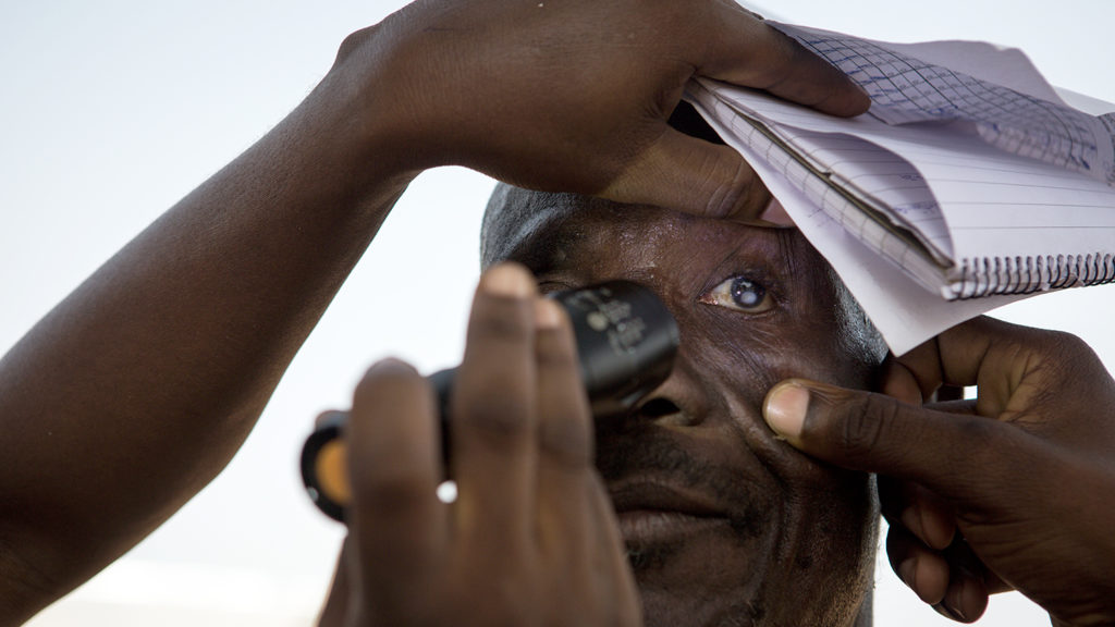 En mann får øynene undersøkt for grå stær i Ghana.