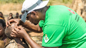 A child in Zimbabwe has his eyes checked by a health worker.