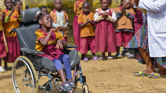Lesline, som er rullestolbruker, sammen med klassekameratene på den inkluderende skolen hennes i Kamerun.