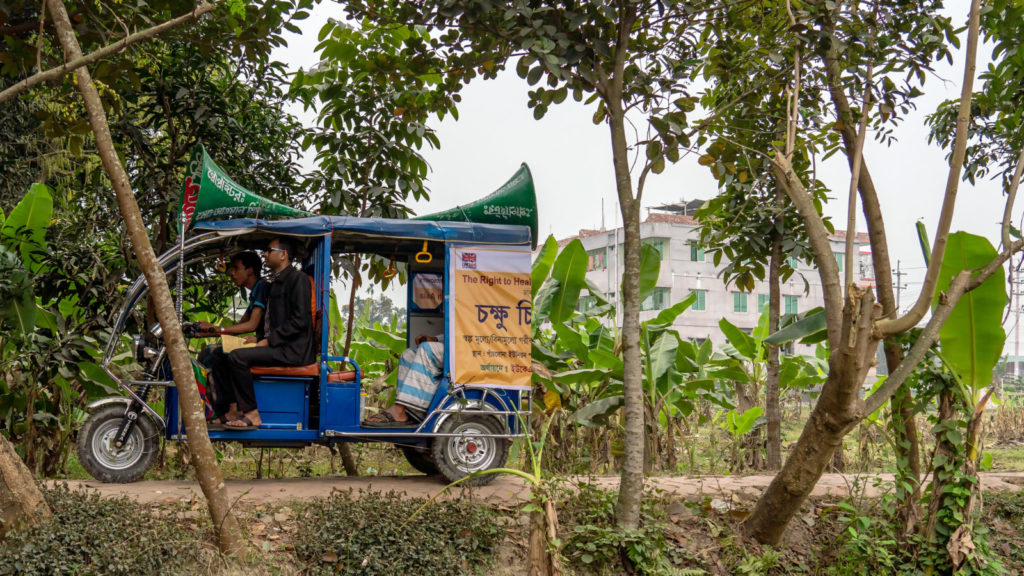 En tuk-tuk kjører gjennom en landsby.