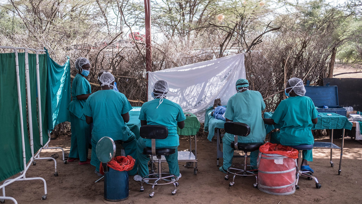 a team of surgeons operate outside.