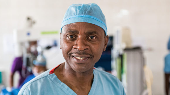 Dr Gerald Msukwa smiler til kamera, med operasjonsantrekket på plass.