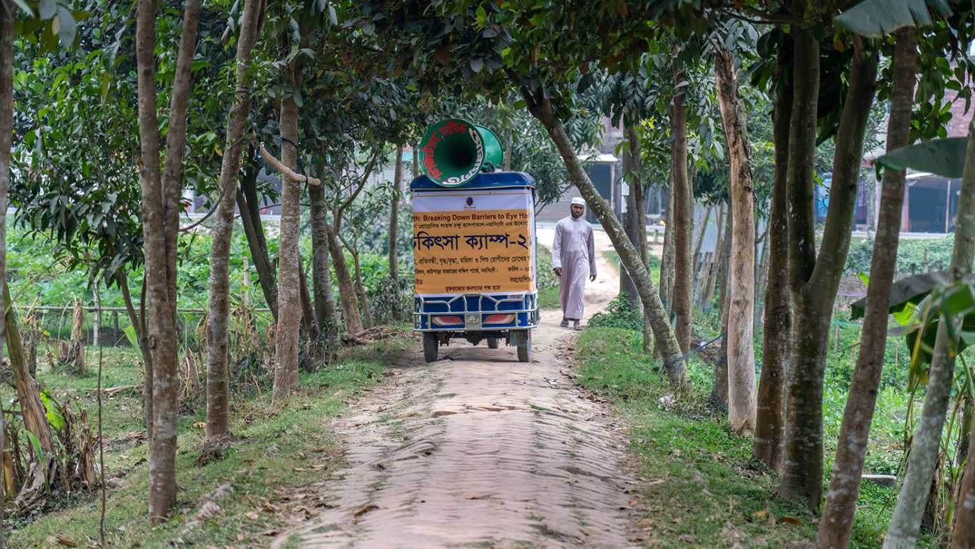 En megafon-moped kjører gjennom en gate i Bangladesh.
