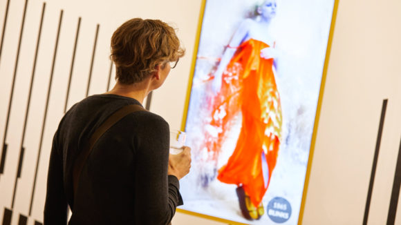 En kvinne betrakter kunst som oppløses i et kunstgalleri