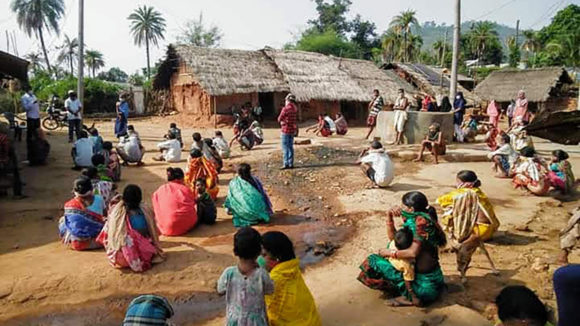 Folk sitter ute i smågrupper og lytter til en veileder.