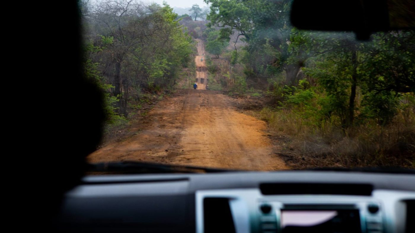 En humpete grusvei i Zambezi-provinsen sett gjennom frontruten på en bil.