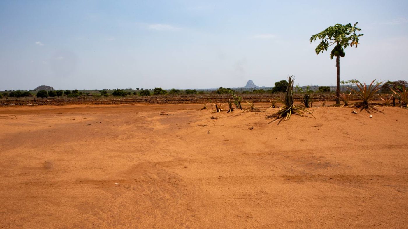 Landskapsfoto viser fjell i bakgrunnen av en landsby i Zambezi, Mosambik.