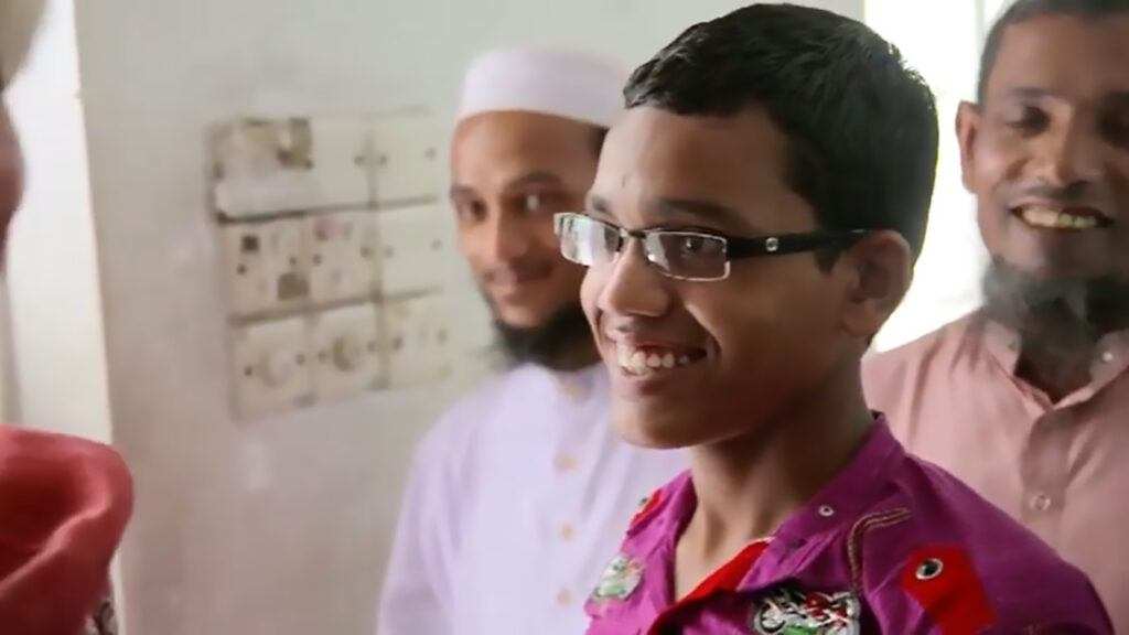 Arif, now 13 years old, smiles.