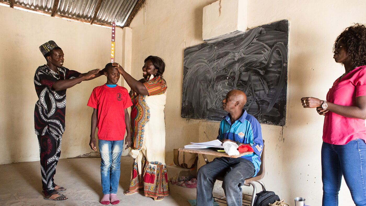 En dreng i skolealderen måler sin højde for at få ormekurbehandling under en skolebaseret massemedicinadministration.