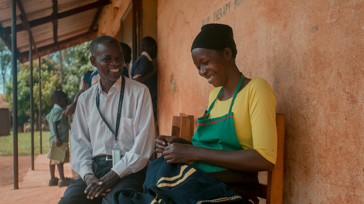 Sylvia laughs as she talks to a man outside.