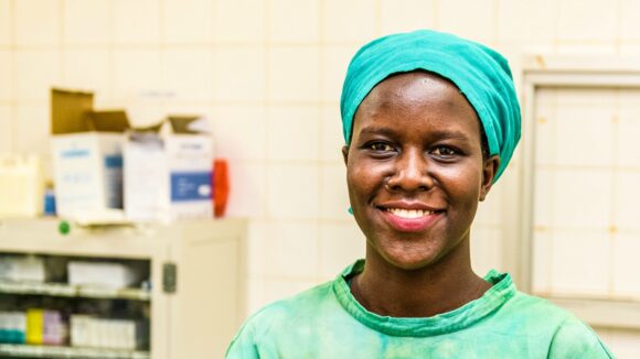 Gladys Atoo smiler mot kameraet i doktoruniformen sin.