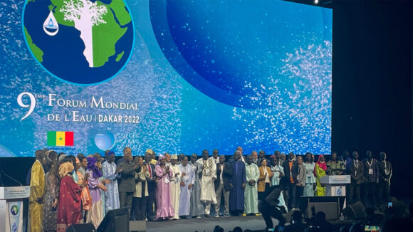 En stor gruppe mennesker står på hovedscenen på World Water Forum.