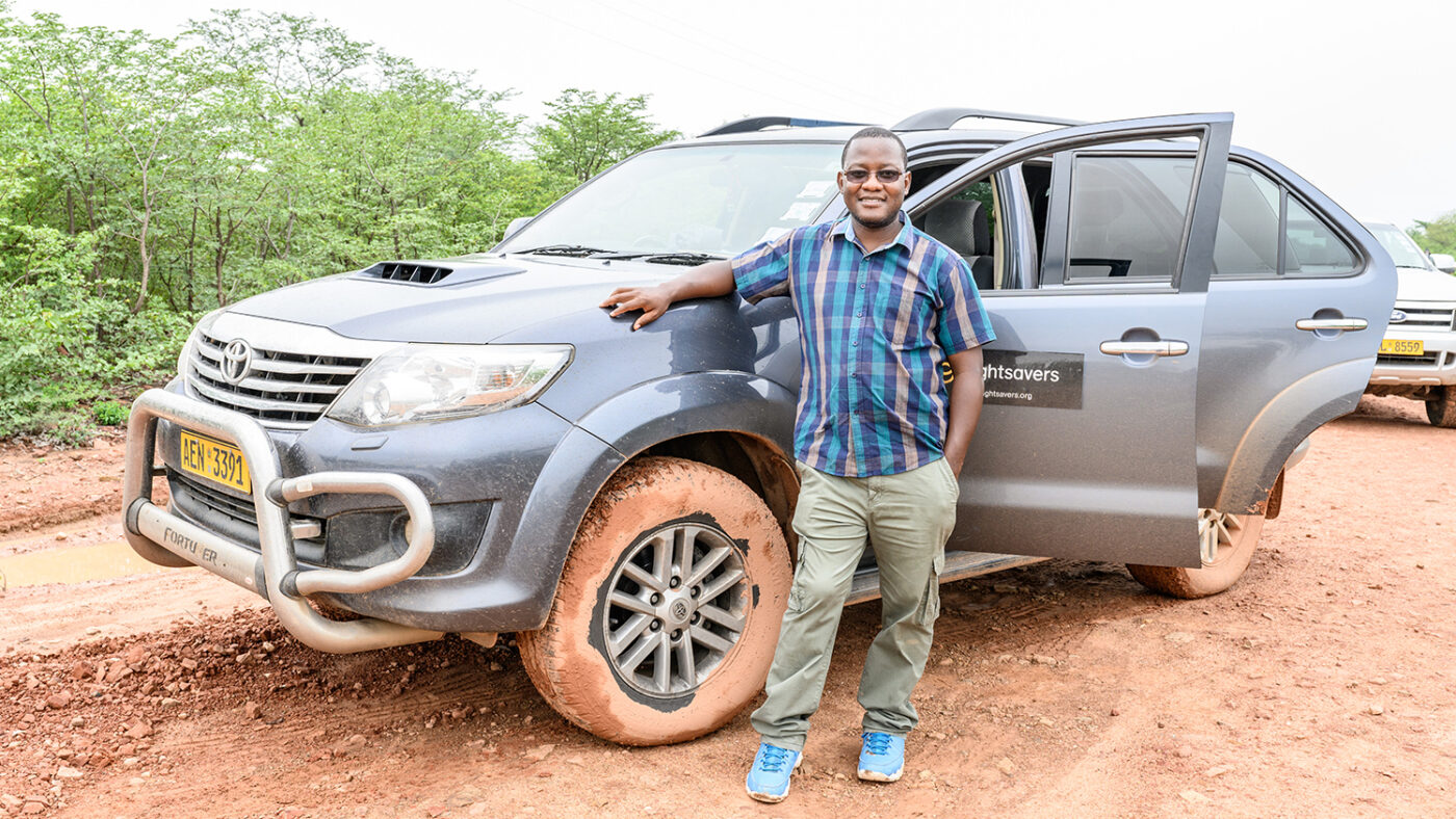 Sightsavers Zimbabwes landdirektør Peter Bare står ved siden av bilen sin i Binga-distriktet.