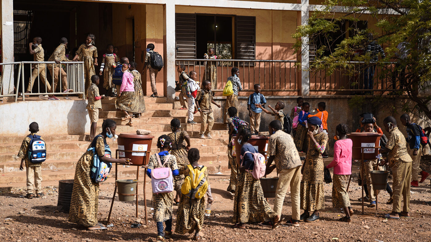 Skoleelever vasker hendene med vann fra utendørskraner.