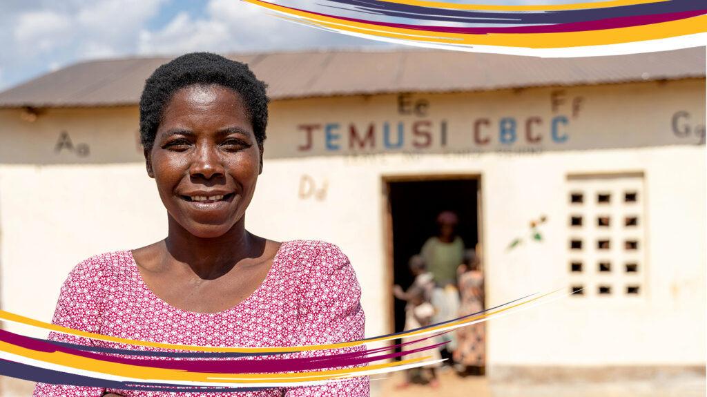 Nora står utenfor førskolen der hun underviser i Malawi, med armene i kors over brystet.