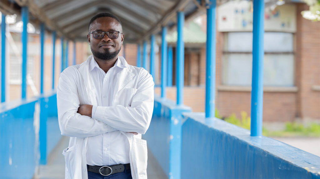 Alinafe, en øyehelselege, står utenfor iført en stilig hvit skjorte og solbriller.