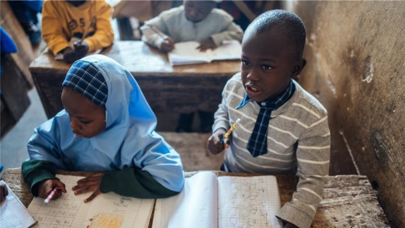 Muhammad sitter ved pulten sin på skolen.