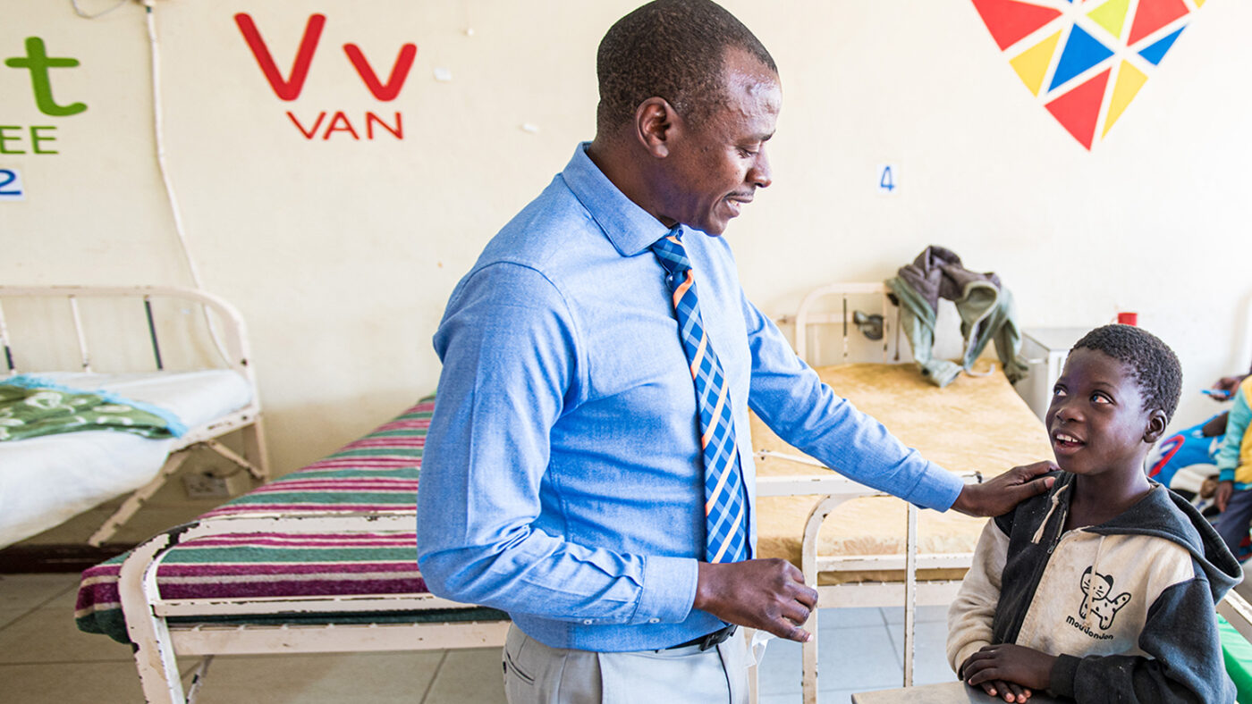 Dr. Msukwa legger hånden sin på skulderen til en ung pasient.