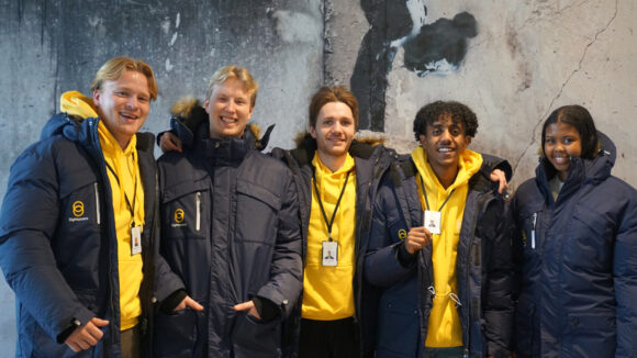 Rekrutterere står sammen og smiler for å ta et bilde iført Sightsavers-uniformer.