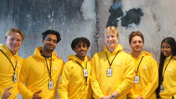 Rekrutterere står sammen og smiler for å ta et bilde iført Sightsavers-uniformer.