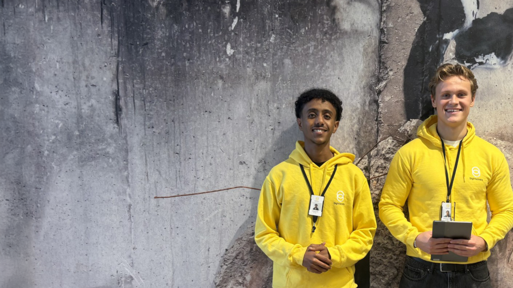 Two fundraisers smiling and wearing Sightsavers-branded clothing.