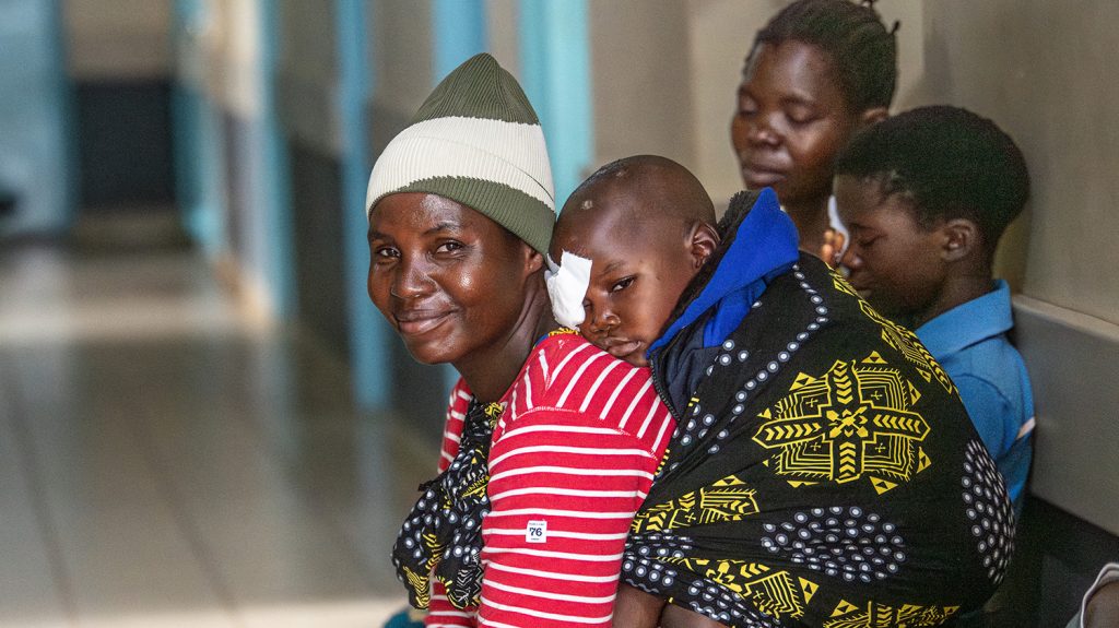 Chancy ligger på ryggen til moren sin, Felister, etter en operasjon mot grå stær på det ene øyet.