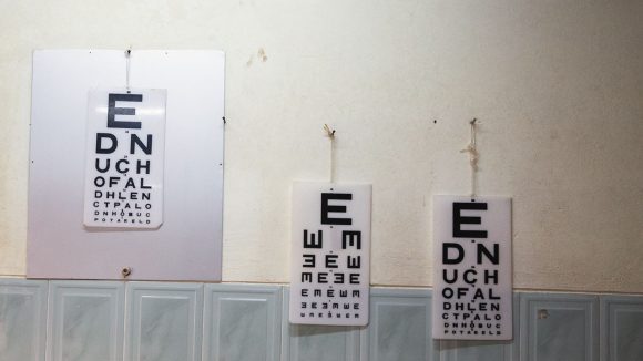 Tre synstestingsdiagrammer henger på en vegg.